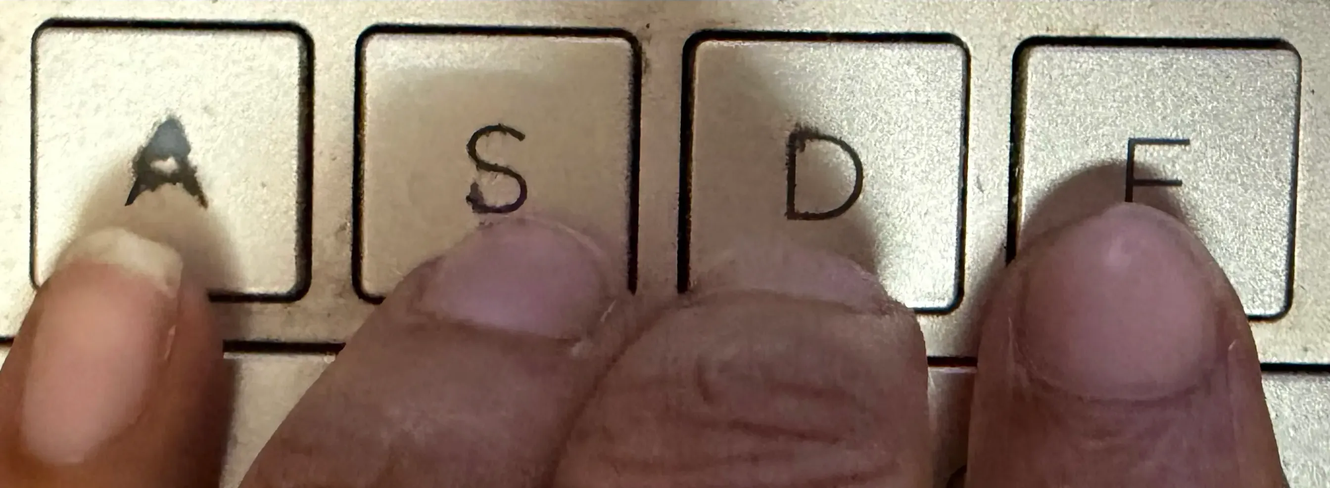 Left hand finger placement on the home row showing the correct position for A, S, D, and F keys in touch typing.